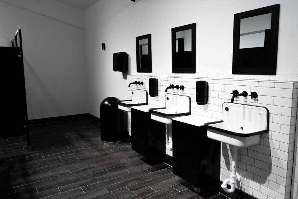 A black and white photo of a bathroom with sinks and mirrors, perfect for a Florida Wedding Venue.