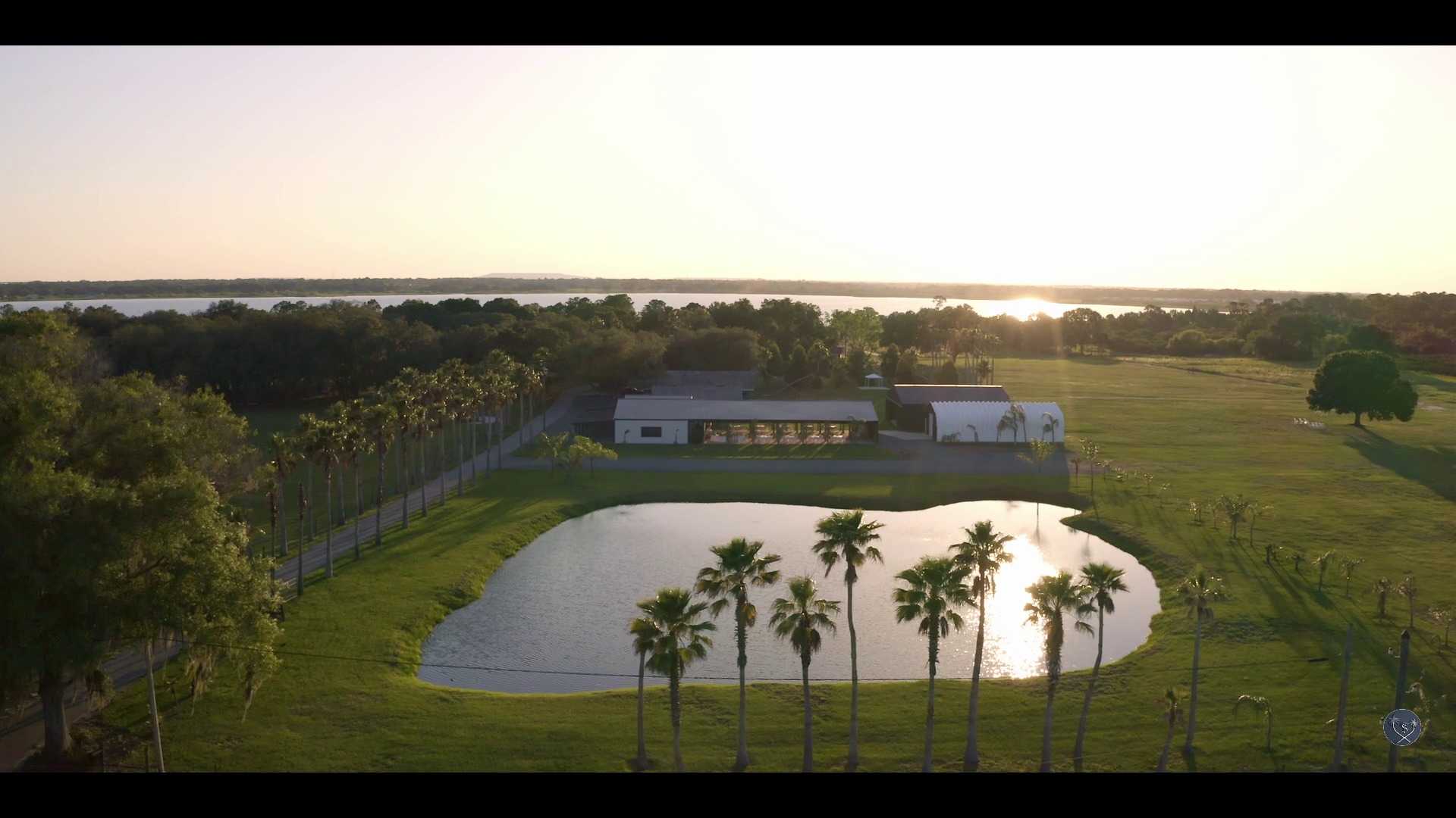 An aerial view of a house with a pond and palm trees, perfect for a Florida Wedding Venue.