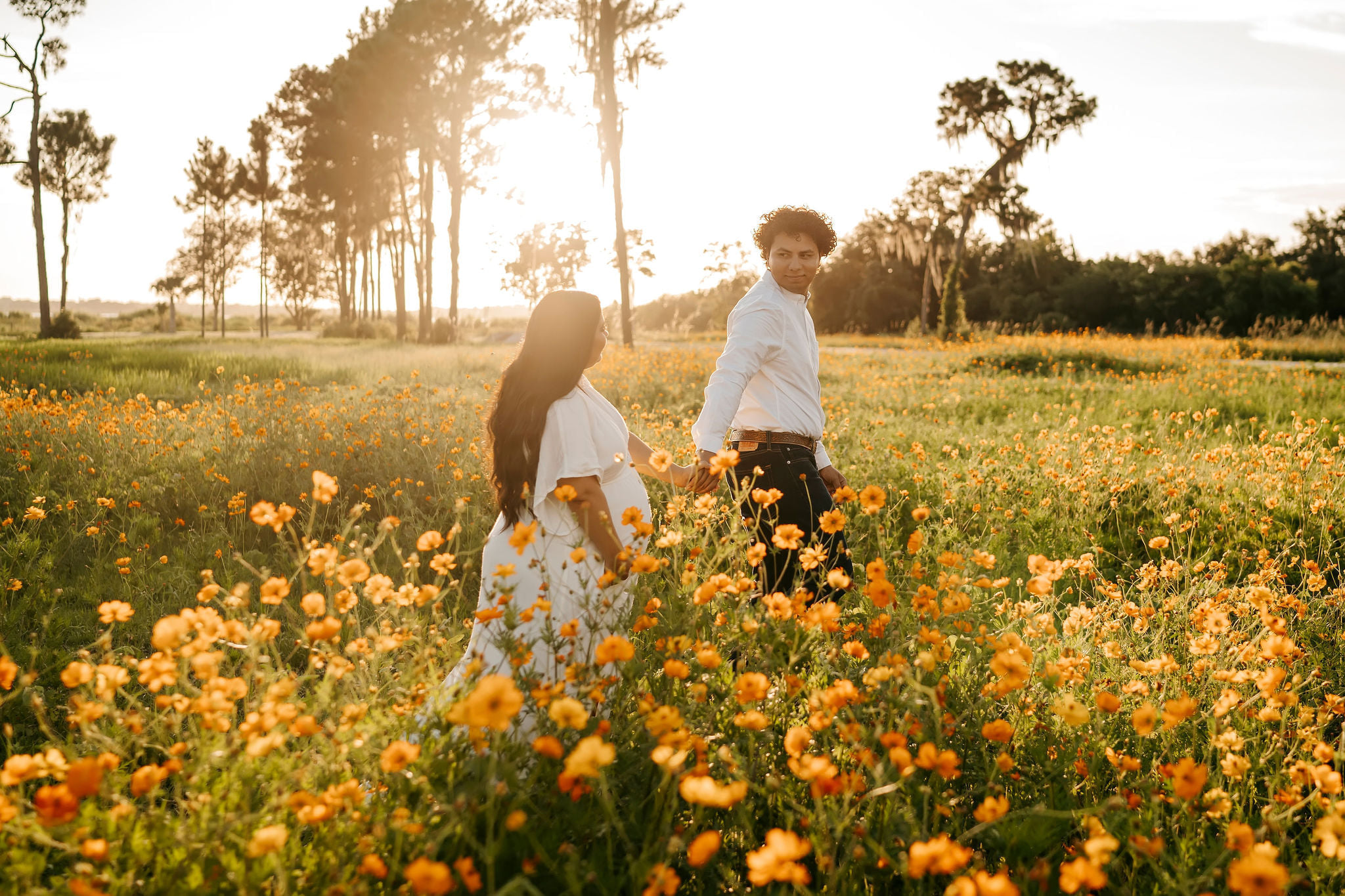 A couple experiencing a romantic sunset stroll through a breathtaking field of poppies, envisioning their dream Florida Wedding Venue.